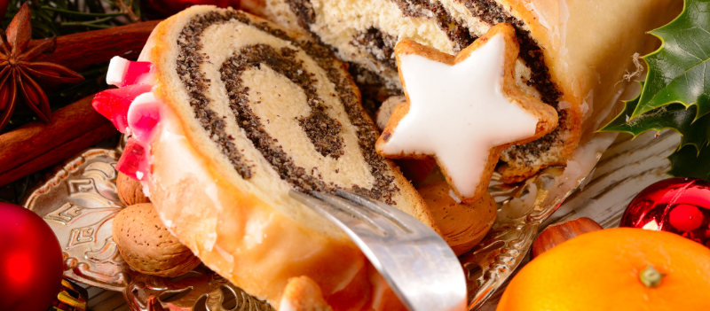 Świąteczny makowiec w otoczeniu dekoracji nawiązujących do świąt Bożego Narodzenia.