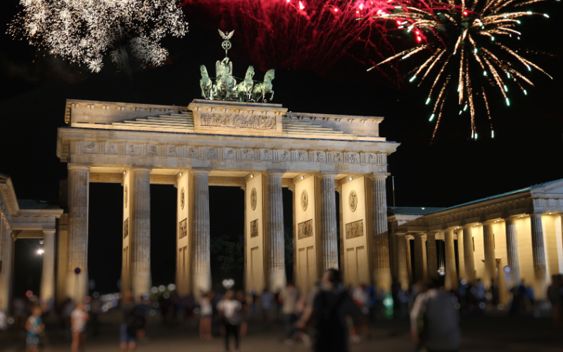 noc sylwestrowa przy bramie brandenburskiej, pokaz fajerwerków i tłum ludzi